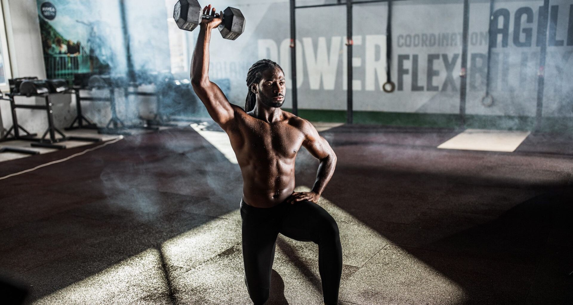 man doing a kneeling overhead press