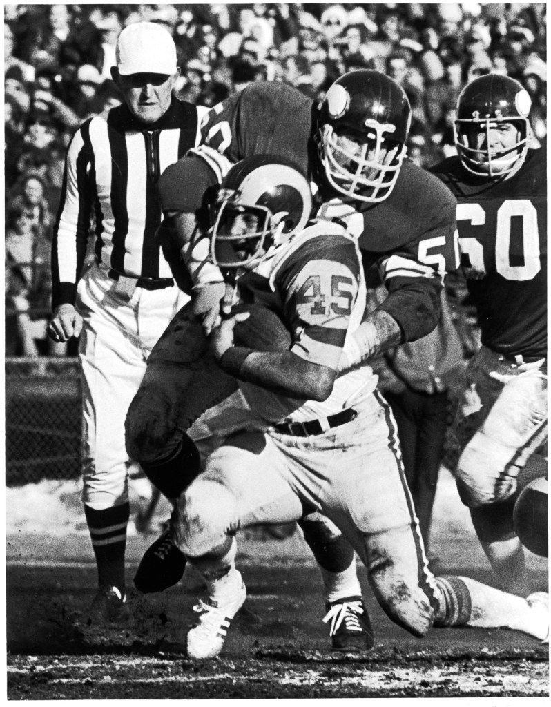Minnesota Vikings linebacker Jeff Siemon tackles Los Angeles Ram running back Cullen Bryant as teammate Wally Hilgenberg looks on during the 1974-75 NFC Championship game at Metropolitan Stadium, Dec. 29, 1974.