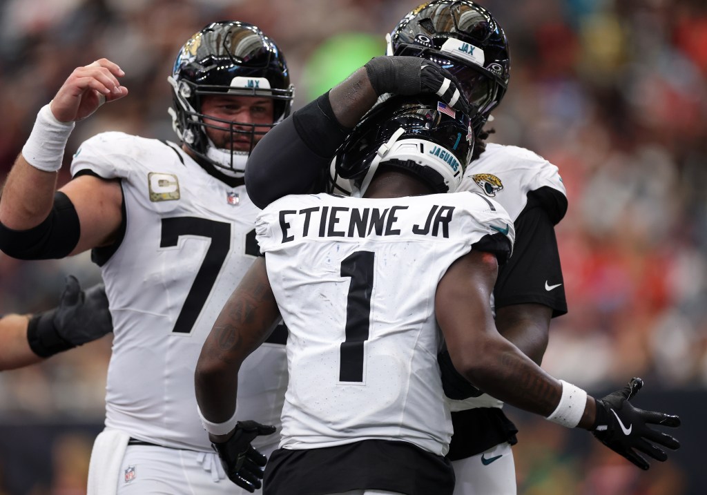 Travis Etienne #1 of the Jacksonville Jaguars is congratulated by teammates after scoring a touchdown 