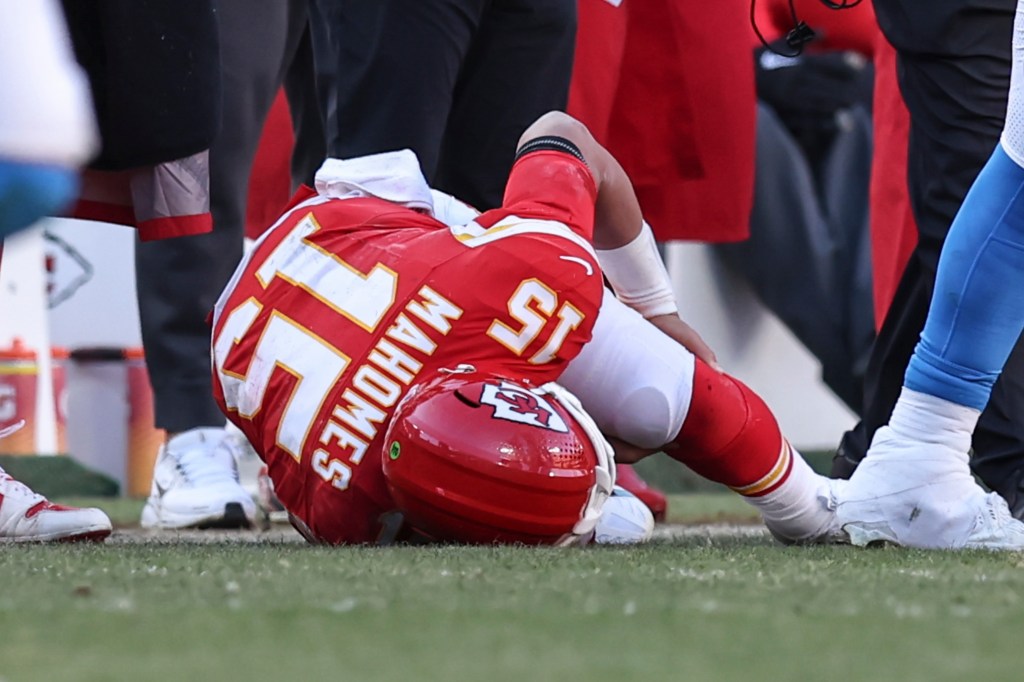 Kansas City Chiefs quarterback Patrick Mahomes (15) lies on the ground holding his knee after being injured in the fourth quarter of an NFL game between the Los Angeles Chargers and Kansas City Chiefs on December 14, 2025 at GEHA Field at Arrowhead Stadium in Kansas City, MO. 