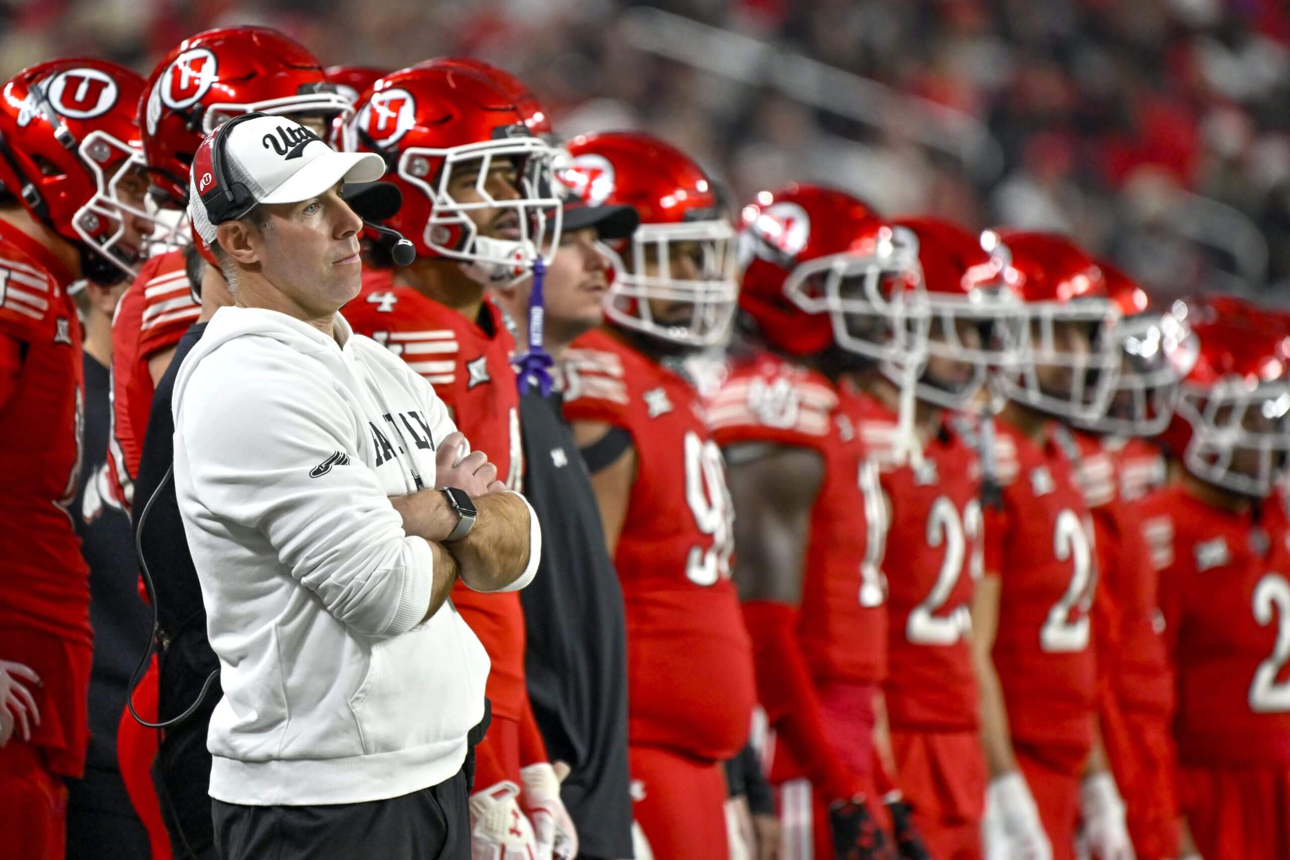 Morgan Scalley crosses his arms on the sideline in front of Utah football players