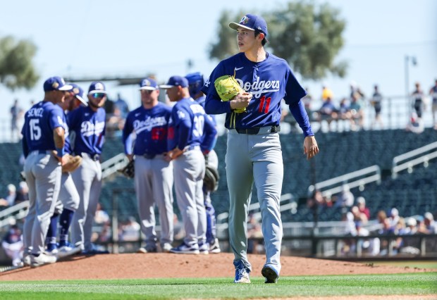 Dodgers pitcher Roki Sasaki walks to the dugout after being removed during the first inning of a Cactus League game against the Cleveland Guardians on Tuesday in Goodyear, Ariz. Sasaki re-entered the game in the second inning and pitched two scoreless innings. (Photo by Mike Christy/Getty Images)