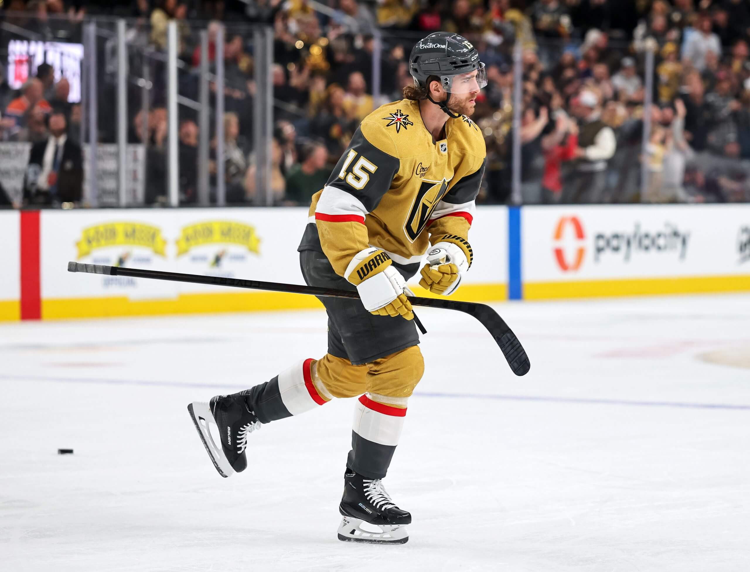 Noah Hanifin skates toward the bench with his stick in one hand after a Vegas goal.