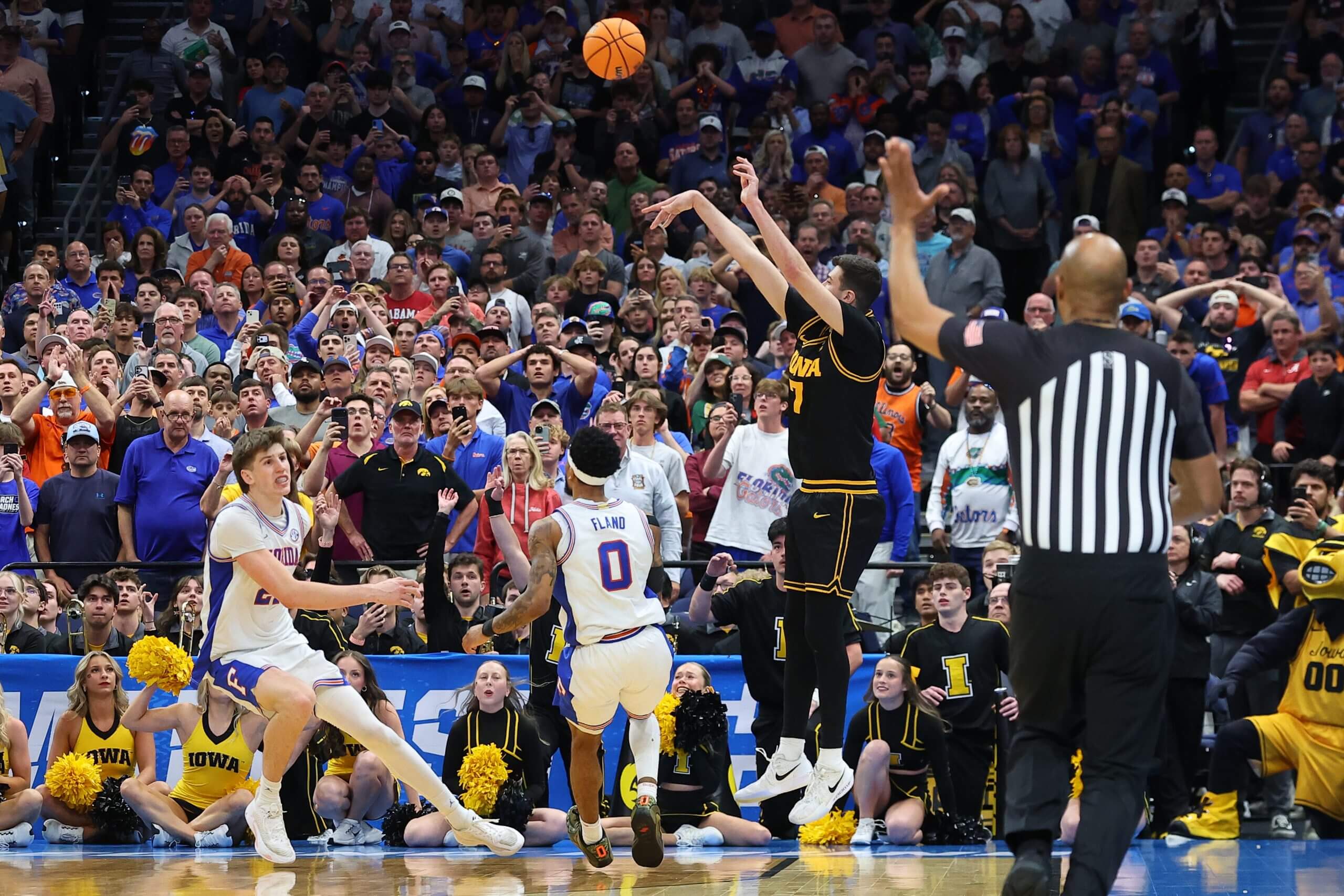 Alvaro Folgueiras of the Iowa Hawkeyes, in dark uniform, attempts a 3-point shot.
