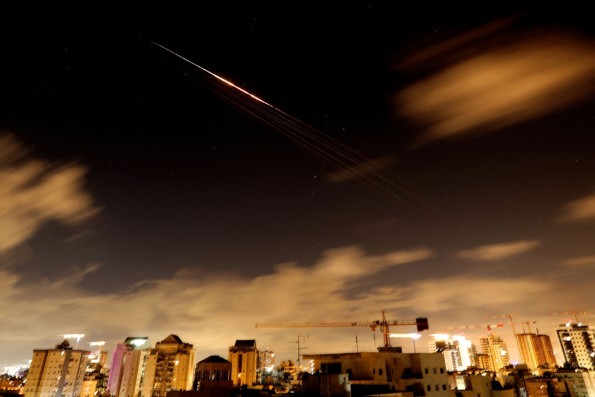 Rocket trails are seen in the sky amid a fresh barrage of Iranian missile attacks above the Israeli coastal city of Netanya on March 27, 2026