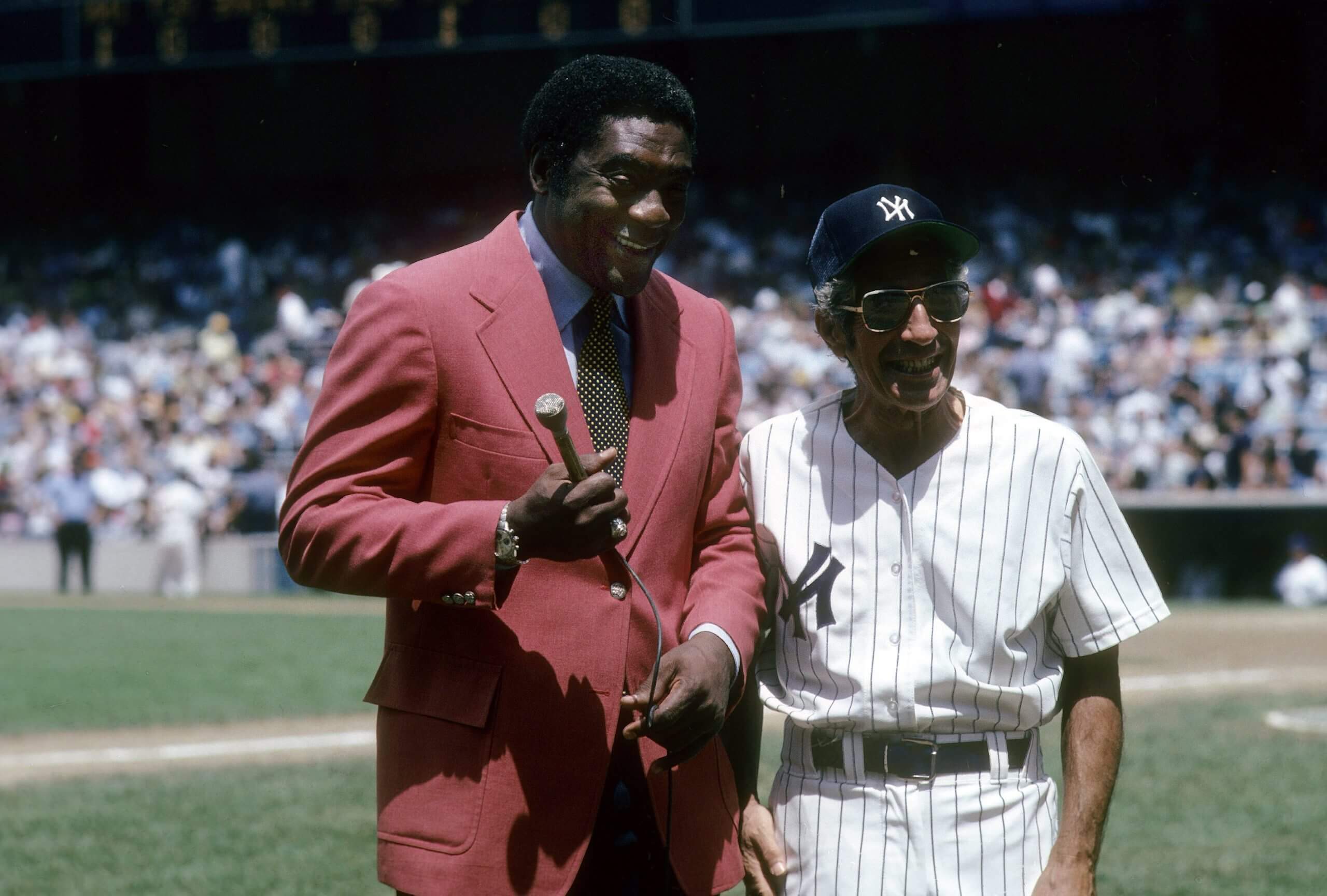 Ex Player Phil Rizzuto (R) of the New York Yankees talks with ex player now radio broadcaster Bill White (L) after an Old timers game circa 1980's at Yankee Stadium in Bronx, New York. Rizzuto played for the Yankees from 1941-42 and 1946-56.