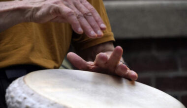 A man plays music at a drum circle Friday, Oct. 4, 2024 in Asheville, N.C., a week after Hurricane Helene upended lives across the Southeast. (AP Photo/Brittany Peterson)