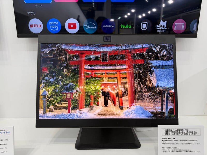 A computer monitor displays a snowy scene of a Japanese shrine with red torii gates and lanterns, while a TV screen above shows streaming app icons like Netflix, Prime Video, Disney+, and Hulu.