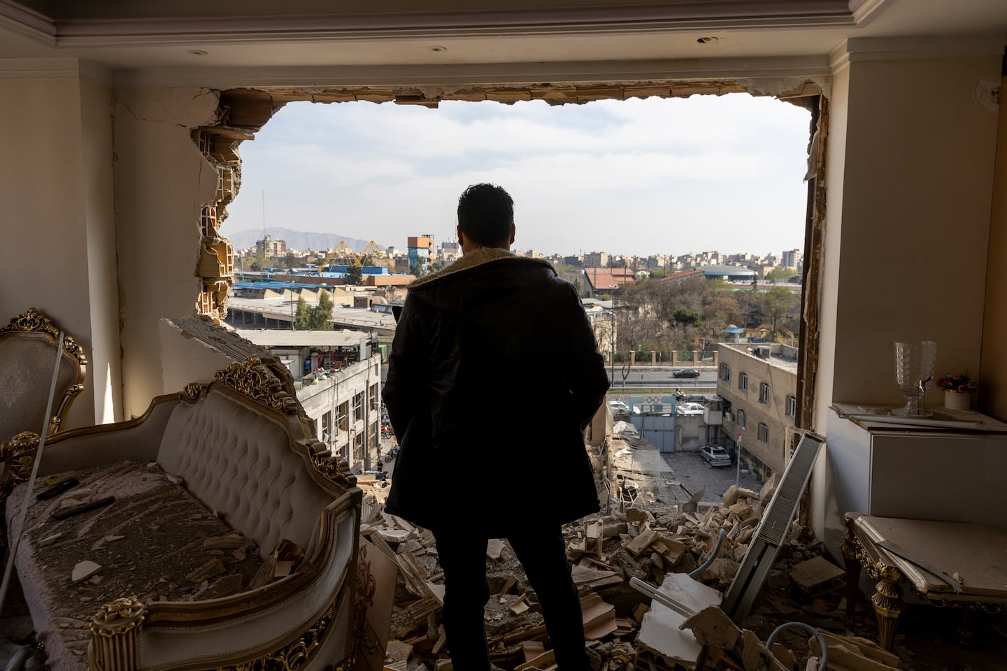 A man stands in a damaged residence on March 14, 2026 at the site of buildings, including a police station, that were destroyed in an airstrike two days ago in the Khani Abad neighbourhood of Tehran, Iran. According to authorities, the police station was empty at the time of the attack but six civilians were killed. The United States and Israel have continued a campaign of air strikes in Iran after launching their joint war on the country on February 28.