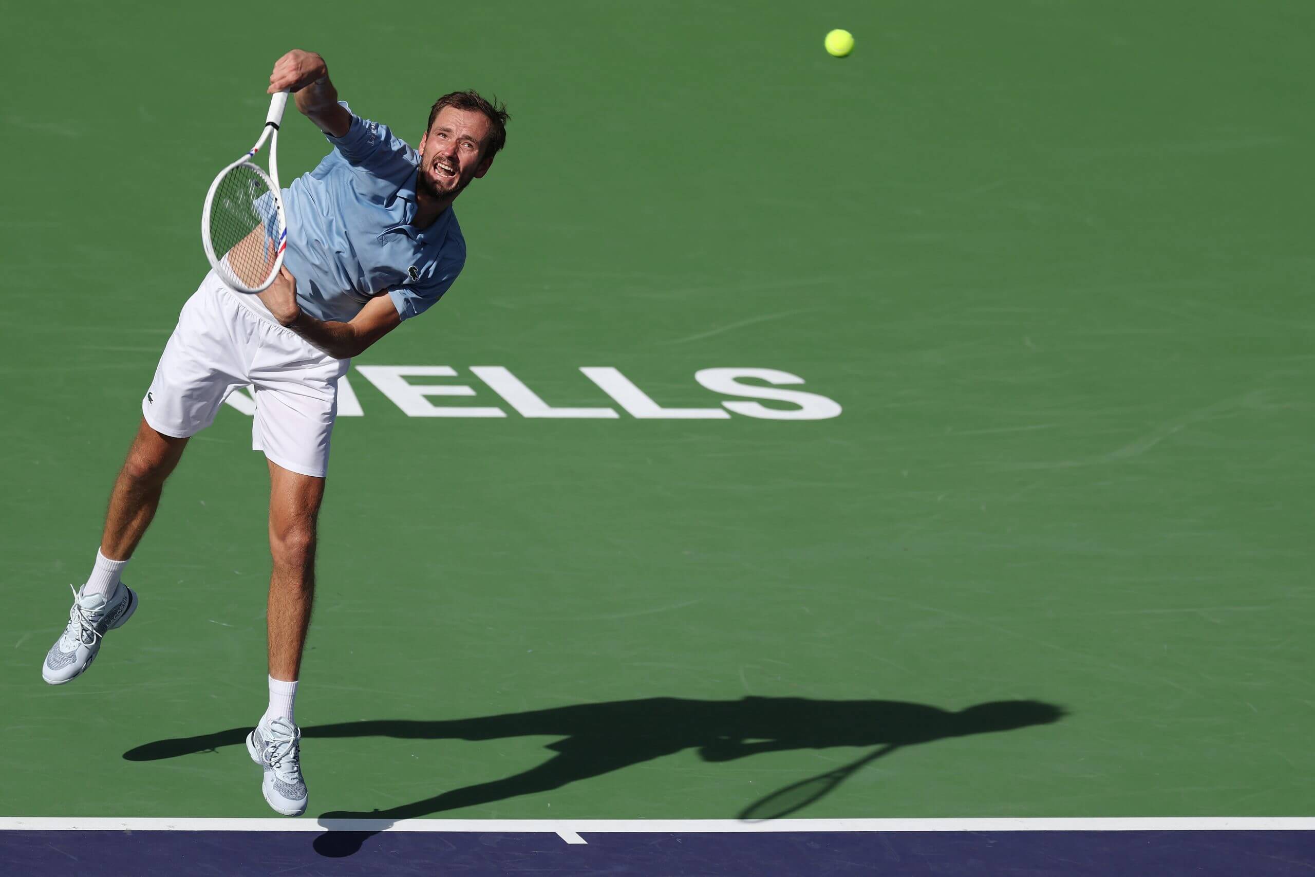 Daniil Medvedev hits a first serve in mid-air.
