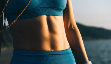 Woman's abs pictured close up in blue activewear