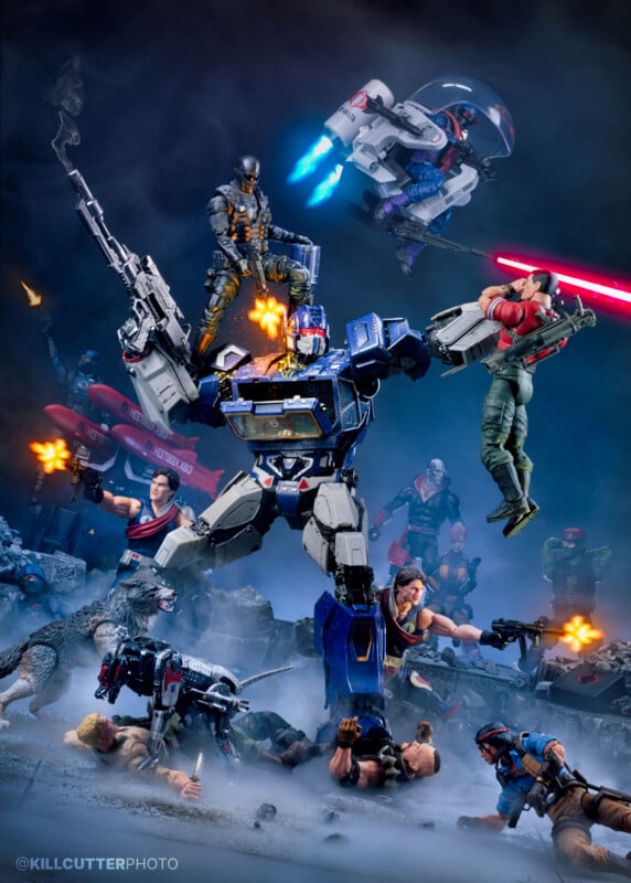 Action figures in a dramatic battle scene with a large robot holding two characters, others firing weapons, laser blasts, and smoke effects. Flying vehicles and soldiers appear in the background, creating an intense atmosphere.