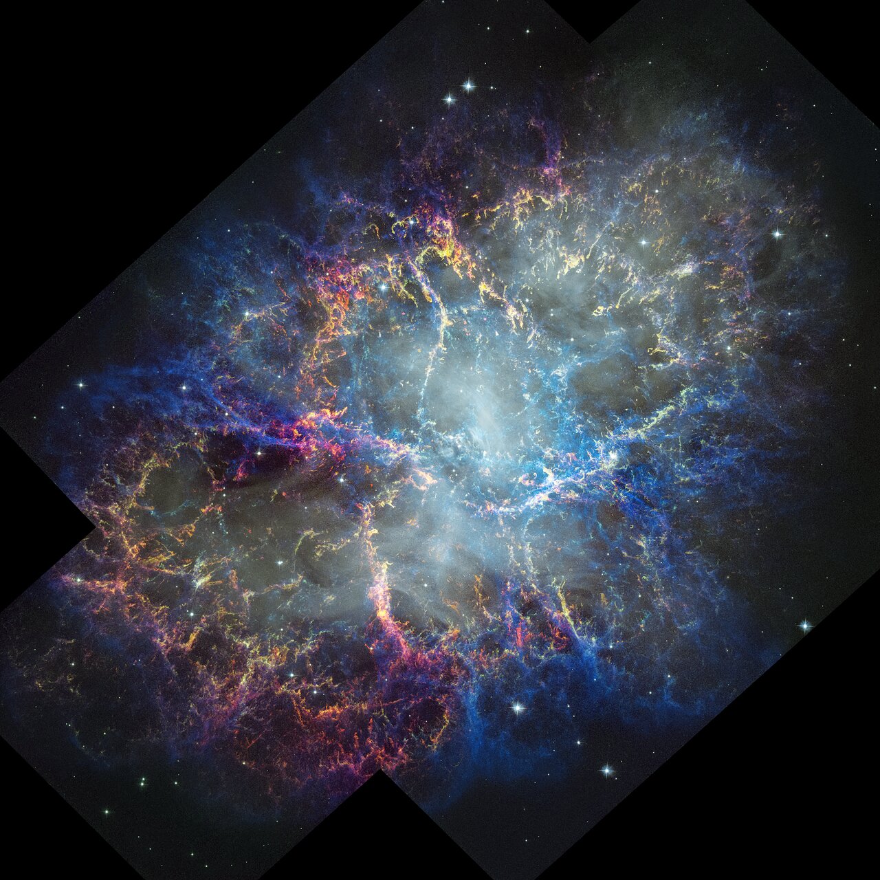 A glowing nebula of pink, blue and orange is seen in the darkness of space