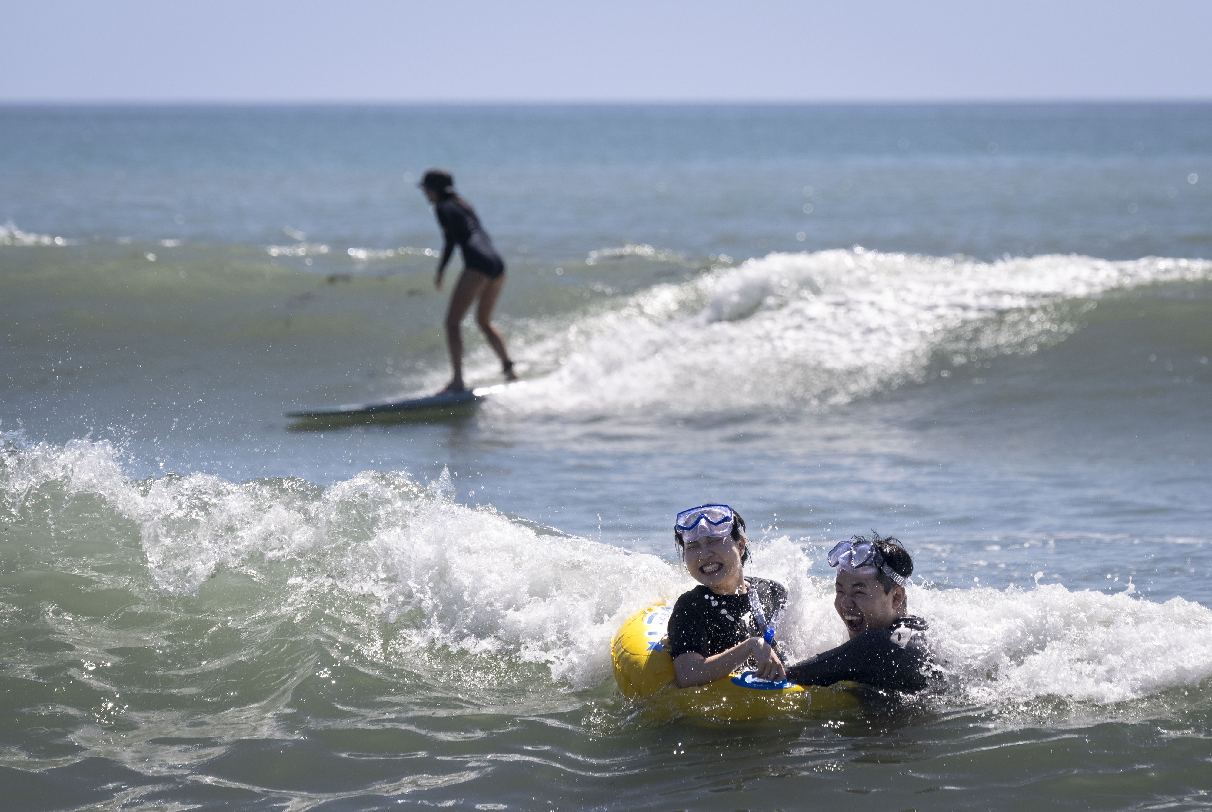Cody and Lily Kim use a float in the waves...