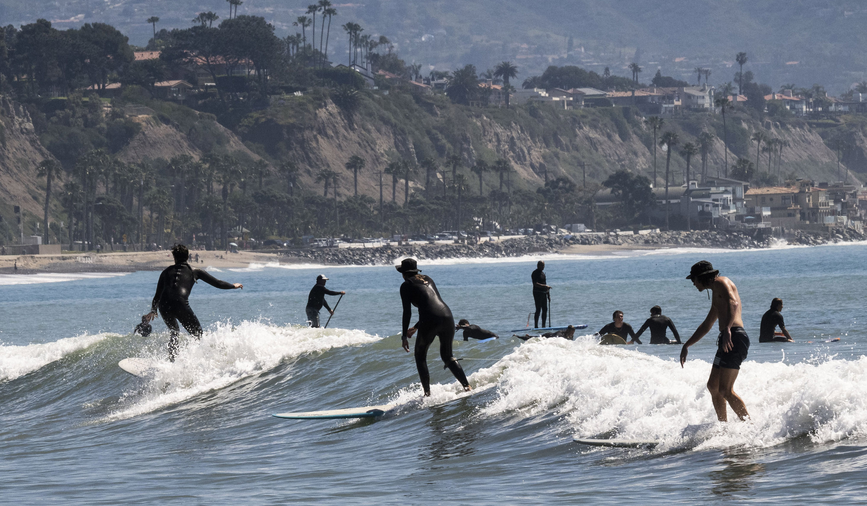 Surfers glide across the waves at Doheny State Beach in...