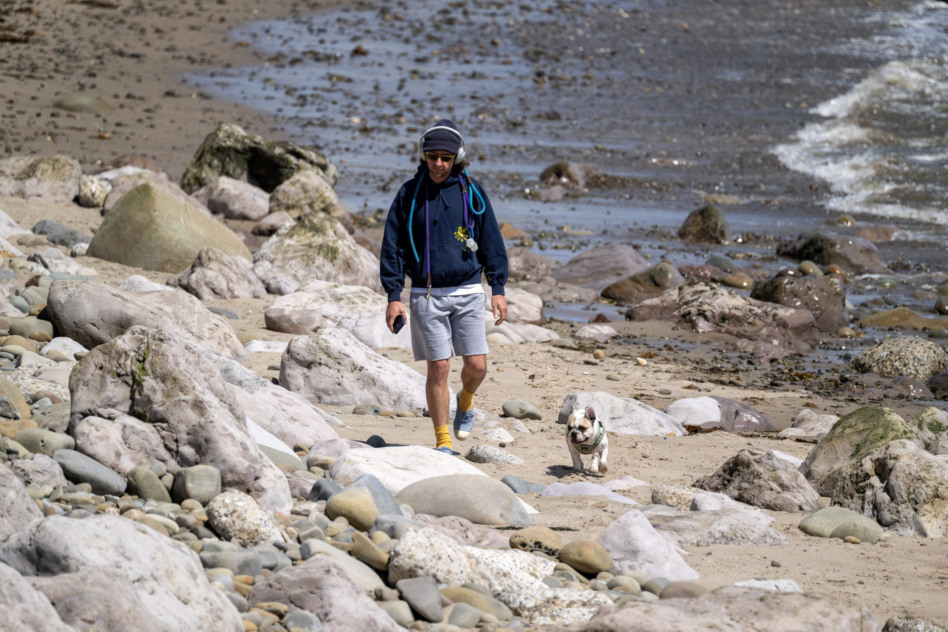 A man walks his dog at Ventura Beach in Ventura...