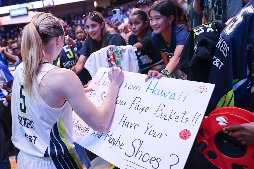 Dallas Wings guard Paige Bueckers (5) gives autographs to fans following her team’s win in...