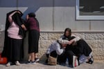 Mourners take cover while air-raid sirens warn of incoming missiles launched by Iran toward Israel during the funeral of Sarah Elimelech and her daughter Ronit who were killed in an Iranian missile attack, in Beit Shemesh, Israel, Monday, March 2, 2026.