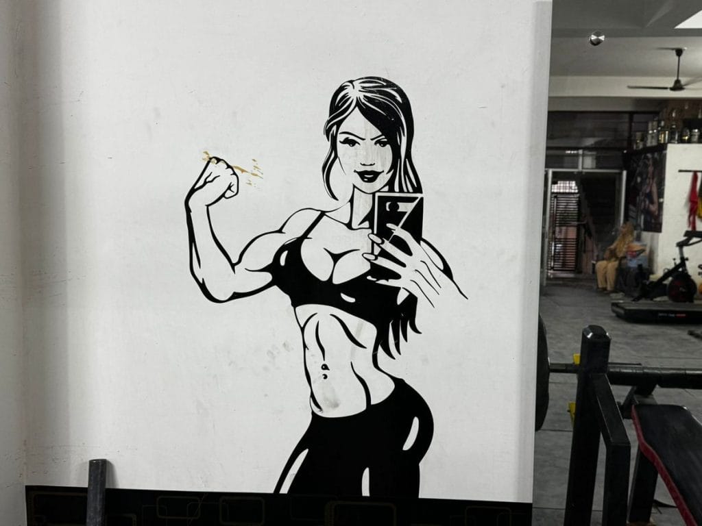 Poster at a gym wall in Alwar. Woman flexing her biceps