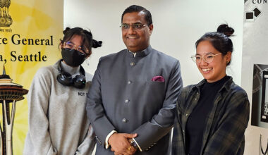 Prakash Gupta posing for a photo with two students.