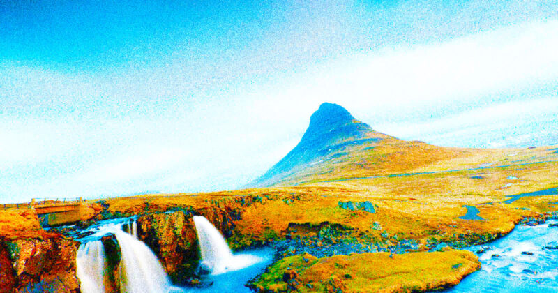 A grassy landscape with a small waterfall in the foreground and a distinctively shaped mountain under a bright, mostly clear sky.