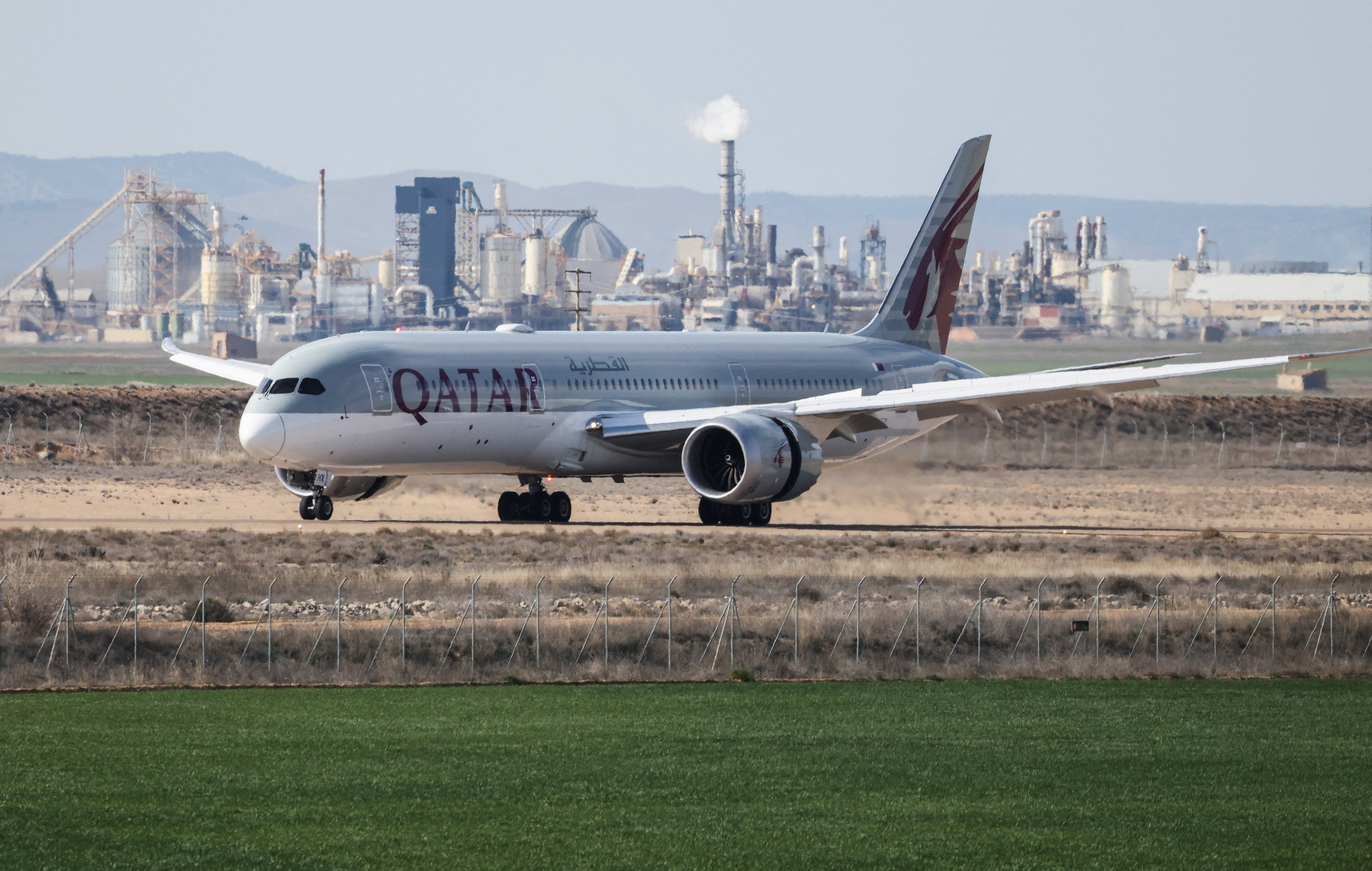 A Qatar Airways plane lands at Teruel Airport as other aircraft remain parked amid airlines withdrawing planes due to the escalating conflict in the Middle East