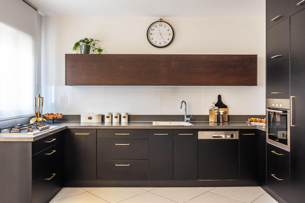 In the kitchen, only the cabinet fronts were replaced with darker finishes (Photo: Yonatan Tamir) דירה לשוטר רווק, עיצוב: דותן ויסמין כהן