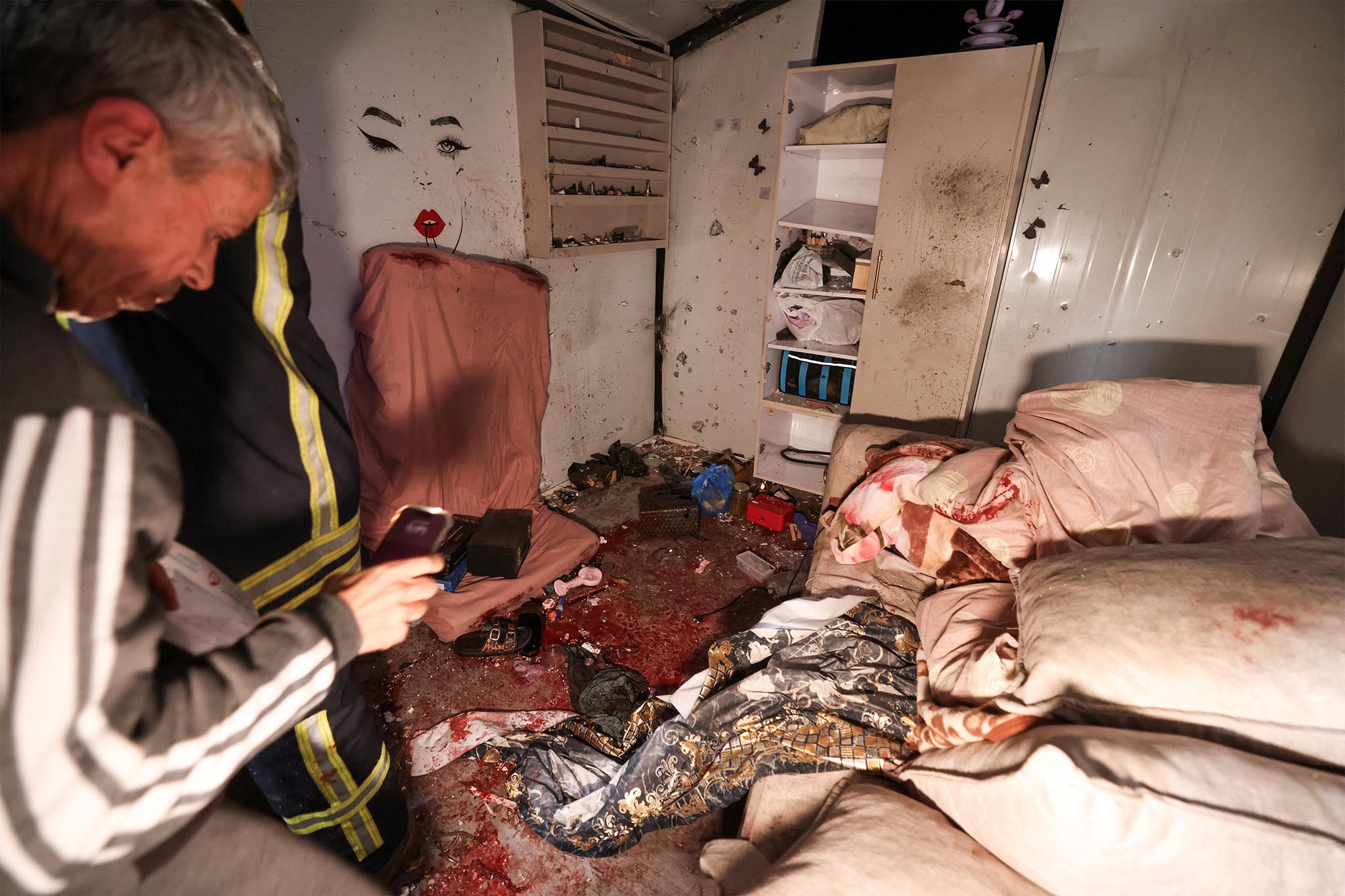 Palestinian civil defence workers inspect the site where shrapnel from projectiles fell in Beit Awa near the Israeli-occupied West Bank city of Hebron on March 18