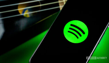 Spotify on a phone next to a guitar