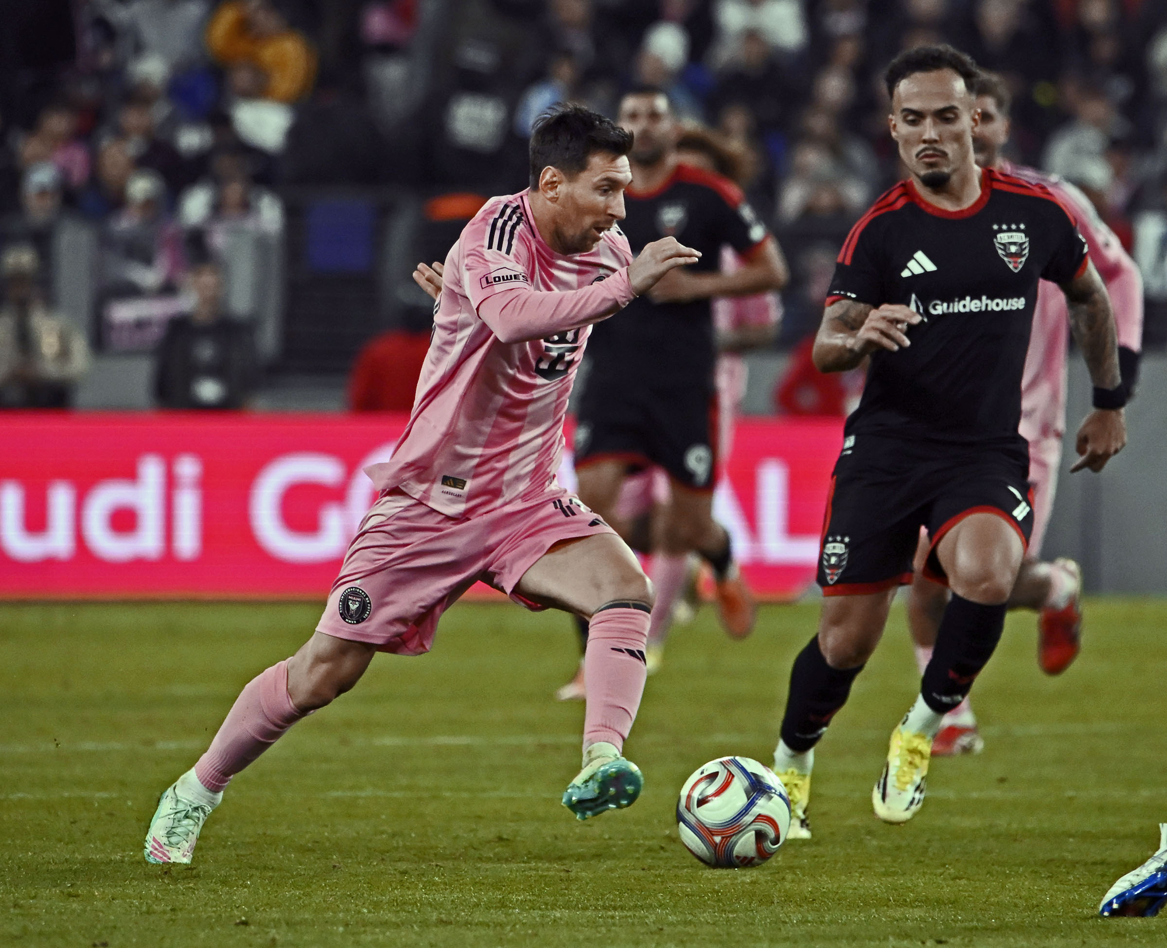 Inter Miamiâs Lionel Messi, left, drives up field against D.C....