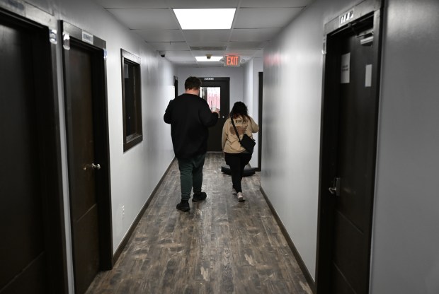 Ethan Ortengren, 18, who has autism, left, and Dezart Stover, a behavior technician (BT), walk down a hallway at Seven Dimensions Behavioral Health as they head outside for exercise in Evergreen, Colorado, on March 16, 2026. (Photo by RJ Sangosti/The Denver Post)