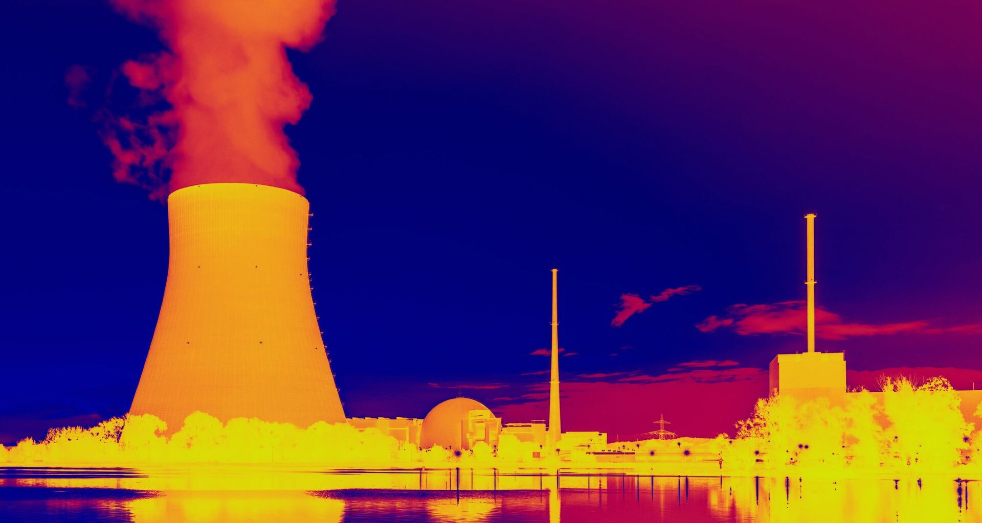 This infrared image shows a glowing orange nuclear power plant releasing hot yellow smoke near various outbuildings with blue water and sky above and below