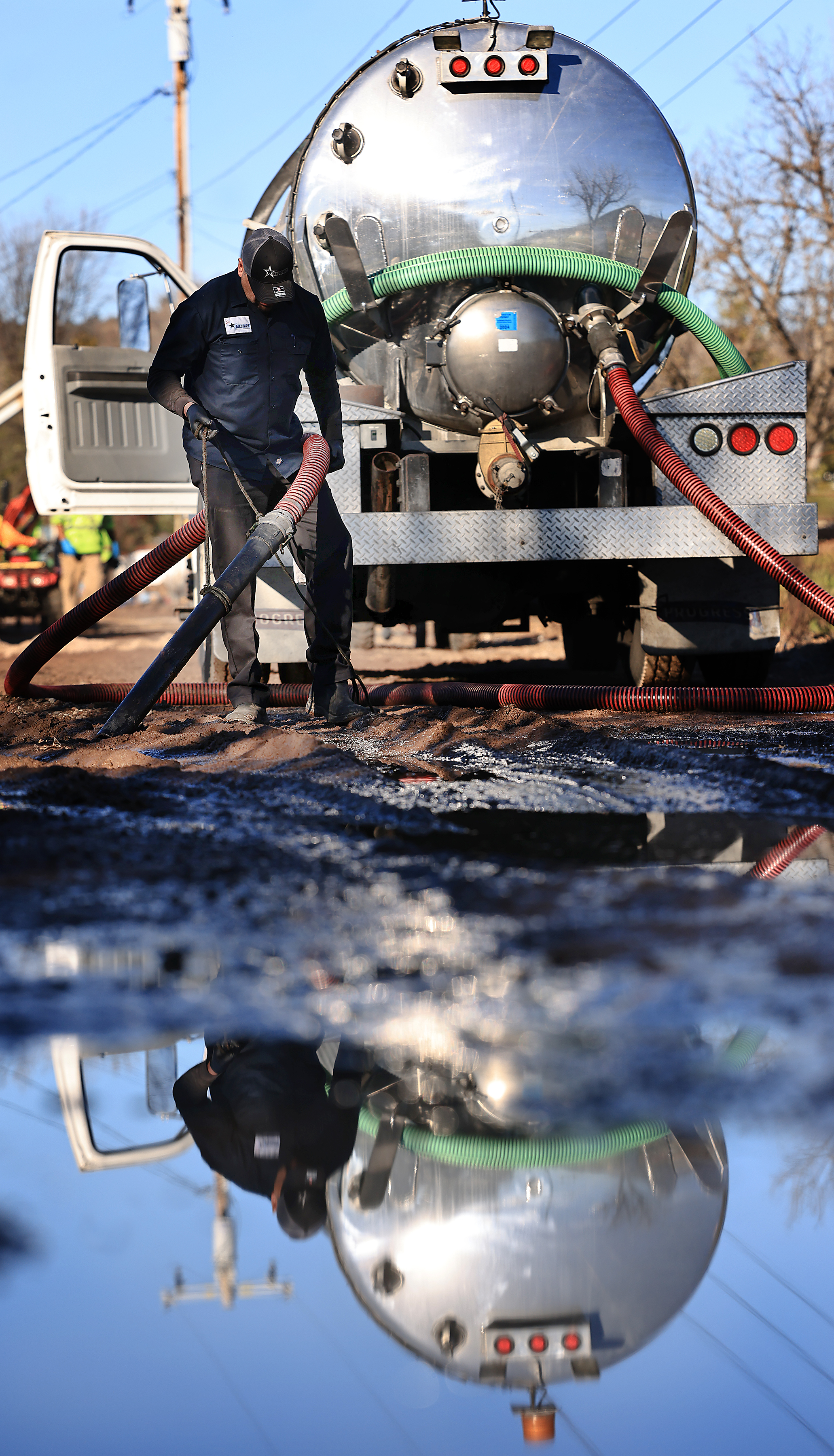 An Allstarz Pumping worker from Sonoma County, vacuums up sewage...