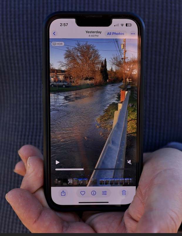 Joe Hulbert displays a photograph of sewage water, Tuesday, Jan. 13, 2026, cascading down Robin Lane, late Sunday in Clearlake, Tuesday, Jan. 13, 2026. (Kent Porter / The Press Democrat)