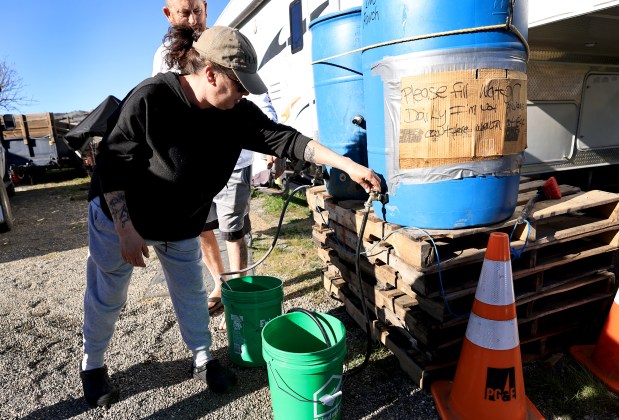 Lindsay and Shawn Heape fill buckets of potable water to be used to flush toilets, wash dishes and other household chores, Wednesday, Feb. 4, 2026, in Clearlake. (Kent Porter / The Press Democrat)
