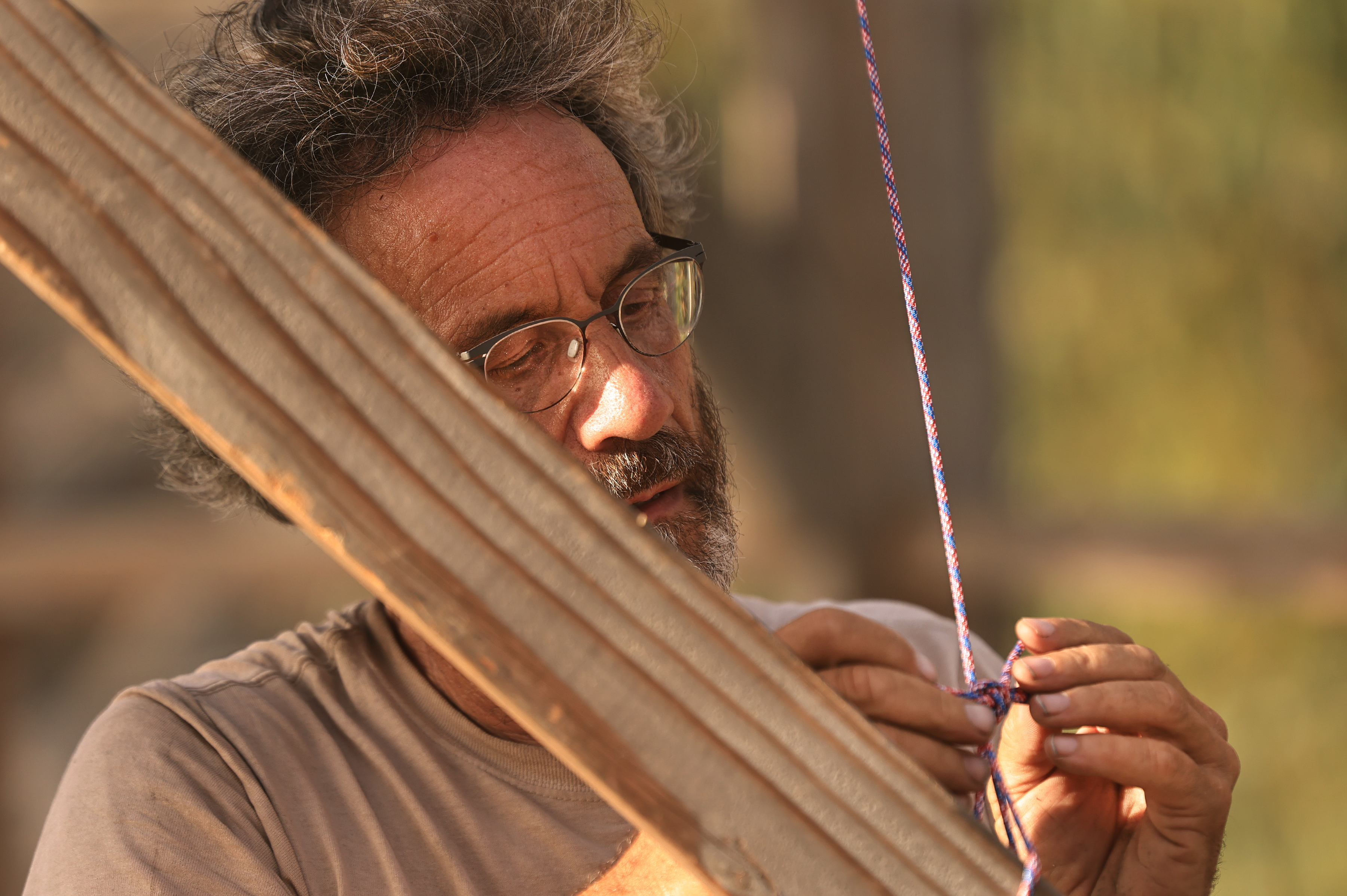 Ken Moholt-Siebert, uses a rope to secure wires surrounding rafters...