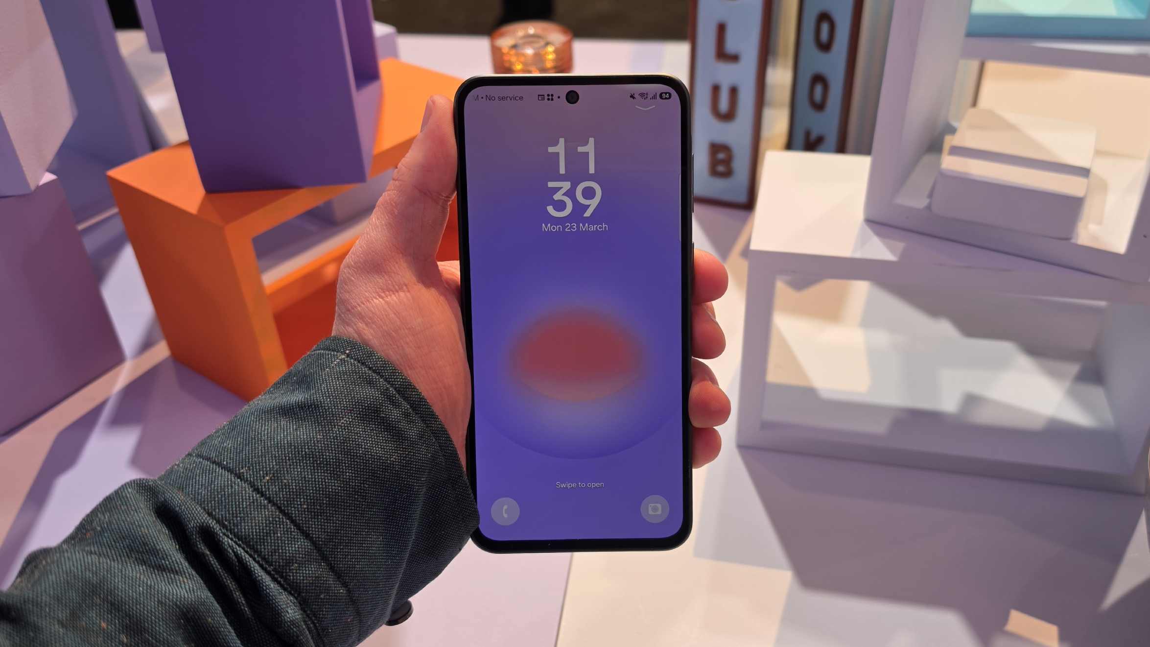 The Samsung Galaxy A37 in a man's hand, showing its lock screen.