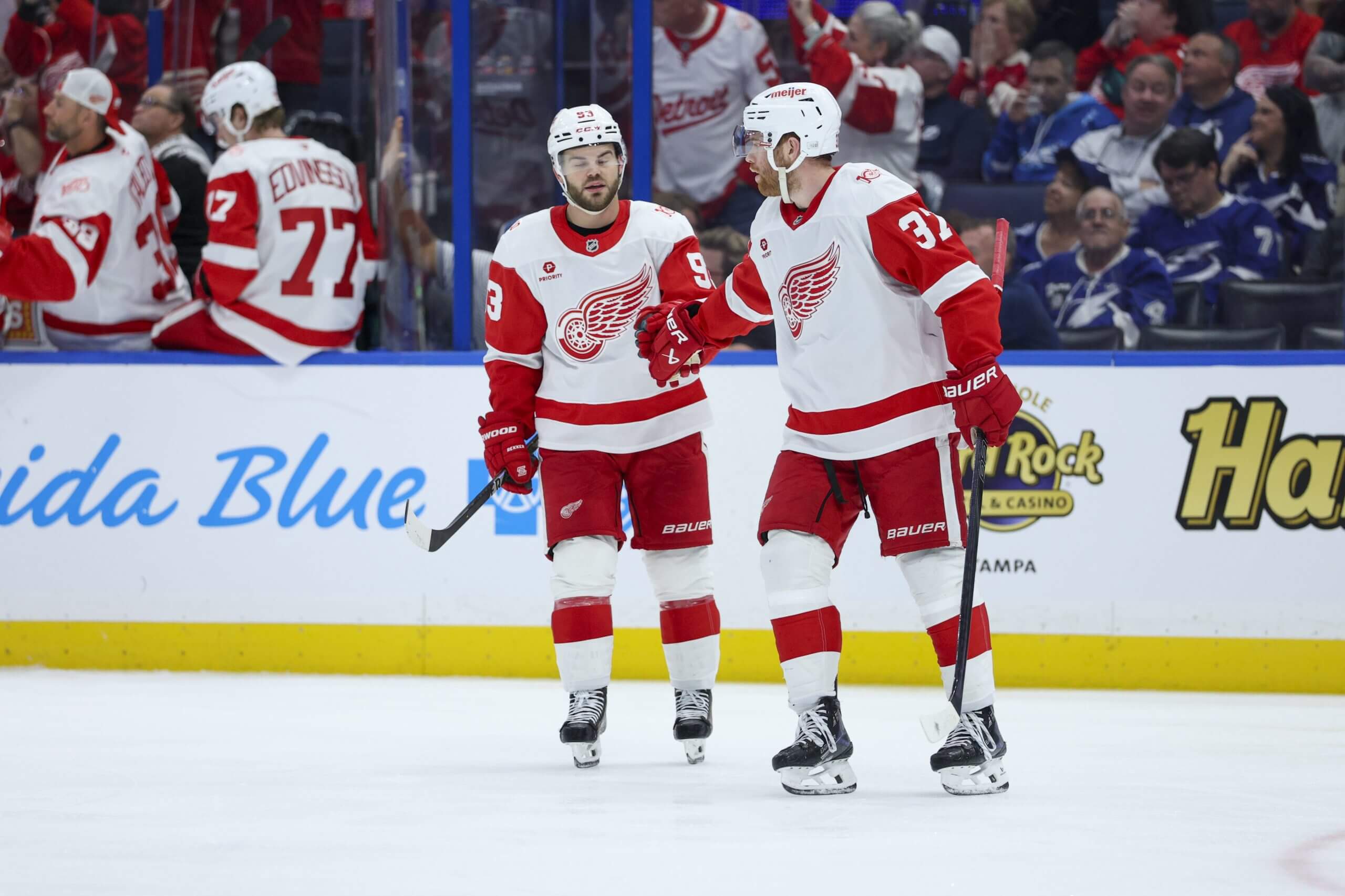 J.T. Compher and Alex DeBrincat fist-bump during a Red Wings game.