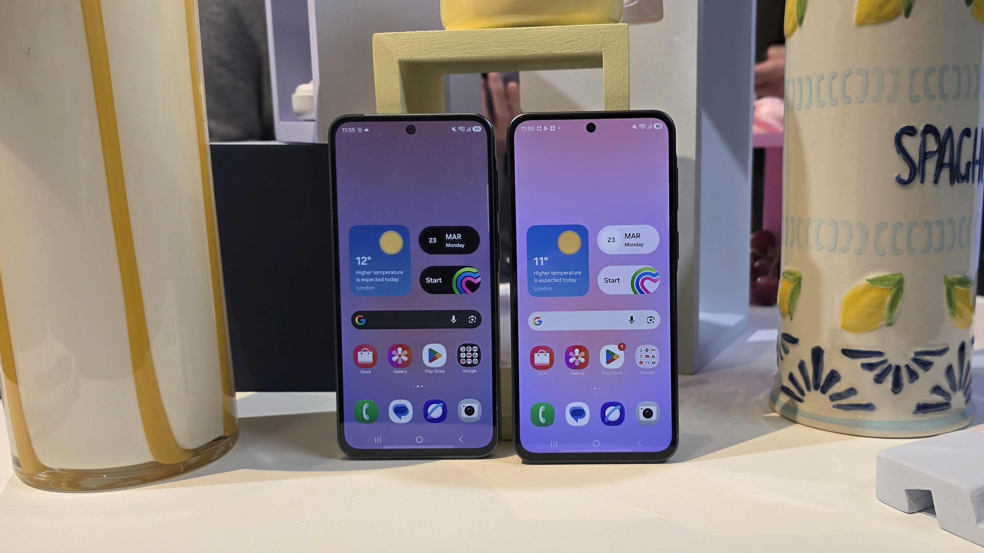 A Samsung Galaxy A37 and Galaxy A57 unit face up next to a spaghetti jar.