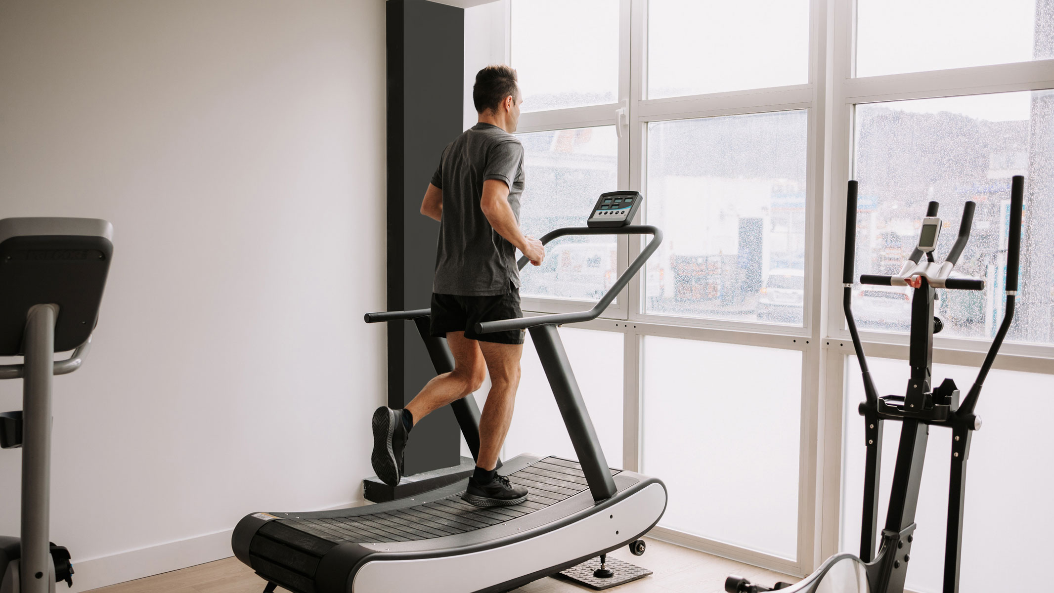 A picture of a man exercising on a treadmill in a home