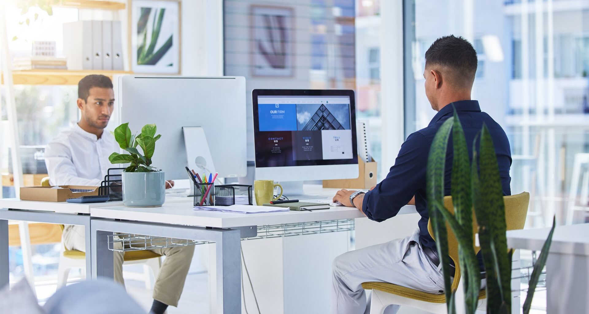 two men working on computers in office
