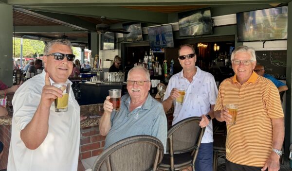 Villager John Graham, third from left, bought the drinks at City Fire after getting his first lucky ace