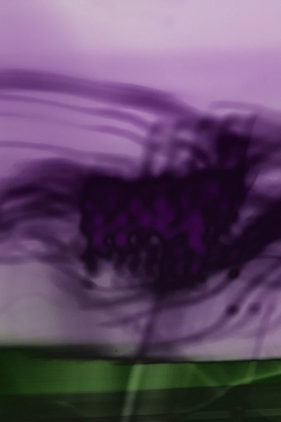 Abstract art with swirling purple and green colors creating a dynamic and vibrant visual effect.