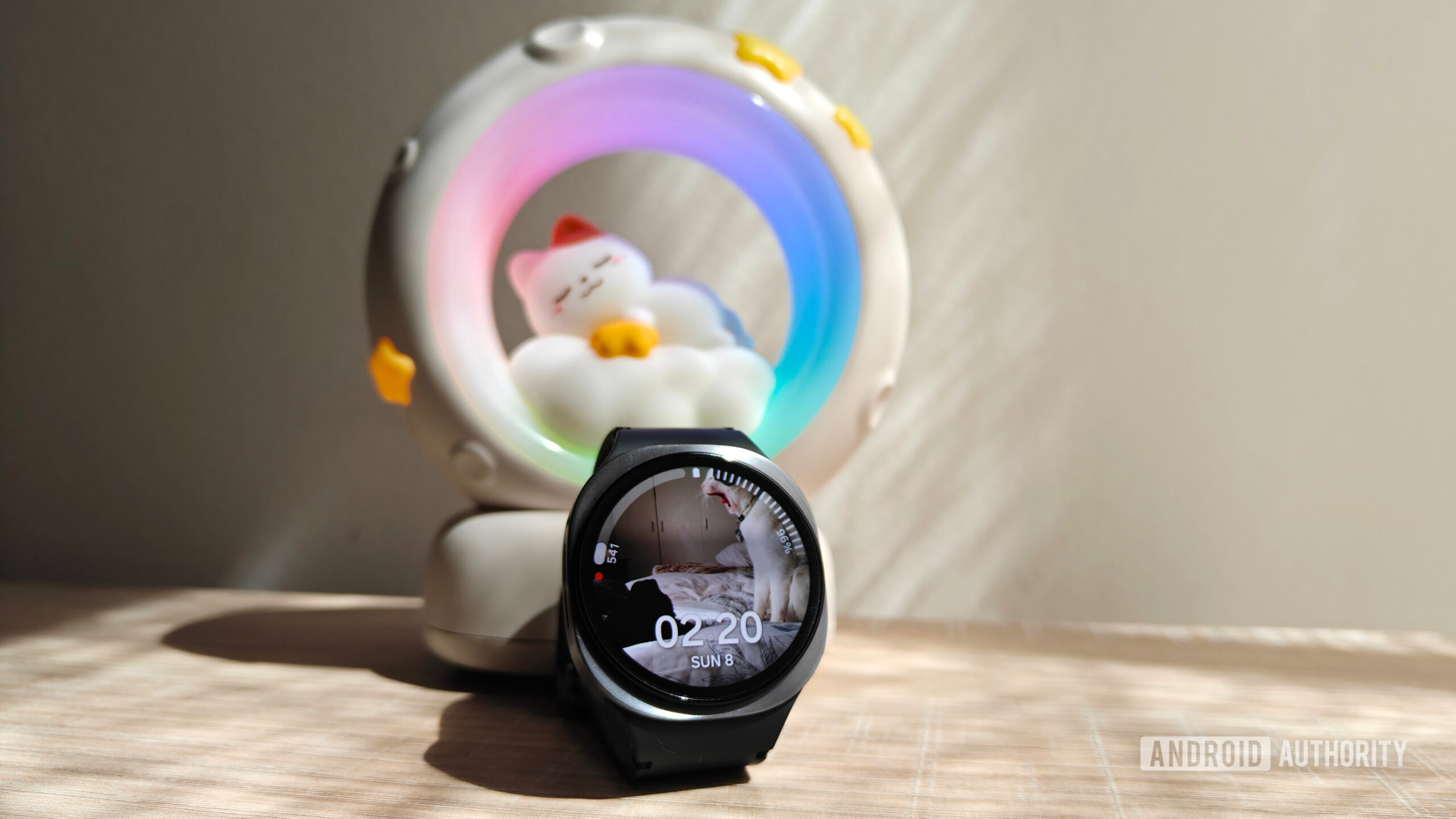 a galaxy watch 8 in front of a night light with a cat sleeping on a moon