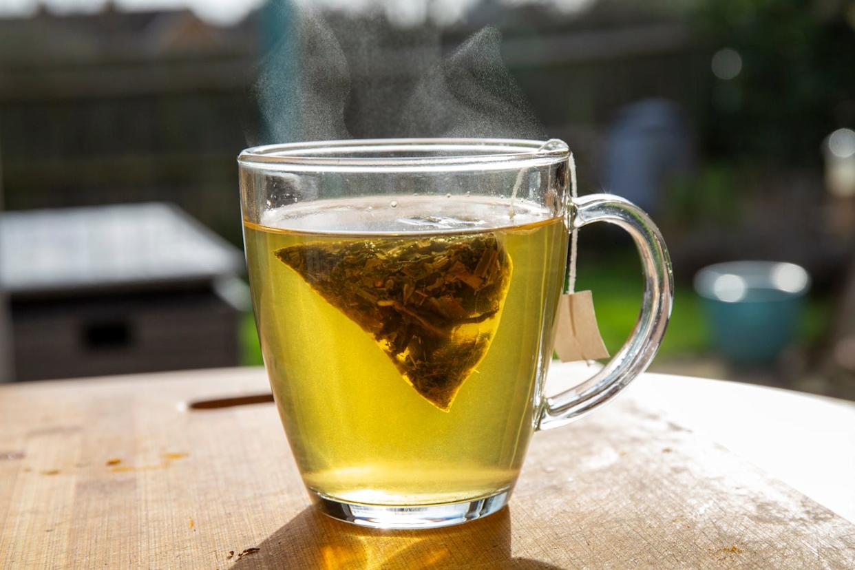 green tea in a clear mug on a table outside