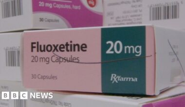 A stack of small boxes of medicine in a pharmacy setting