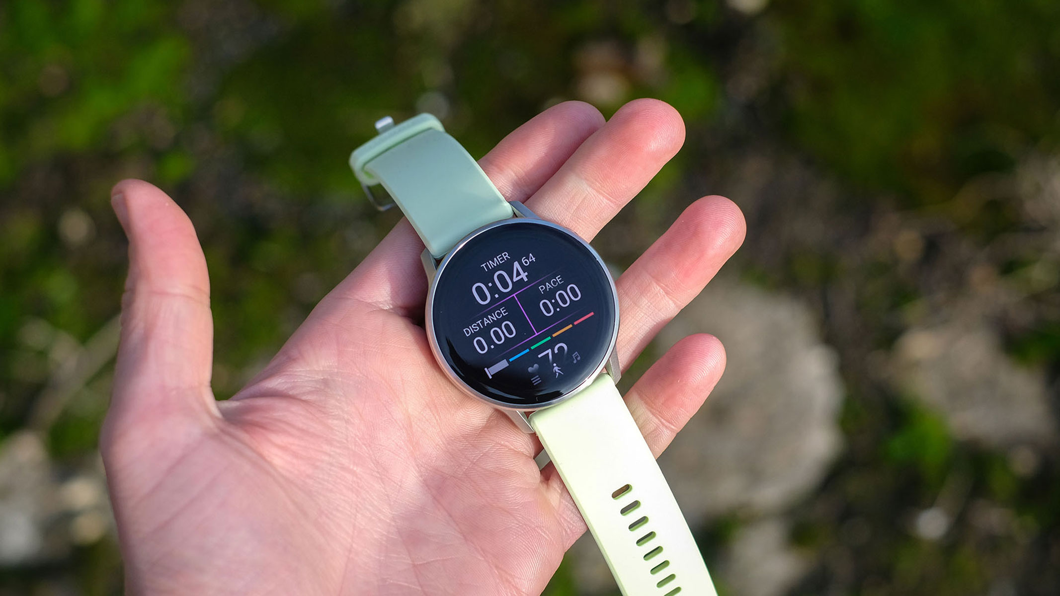 a close-up picture of our reviewer holding the Garmin Venu 4 smartwatch displaying real-time workout stats