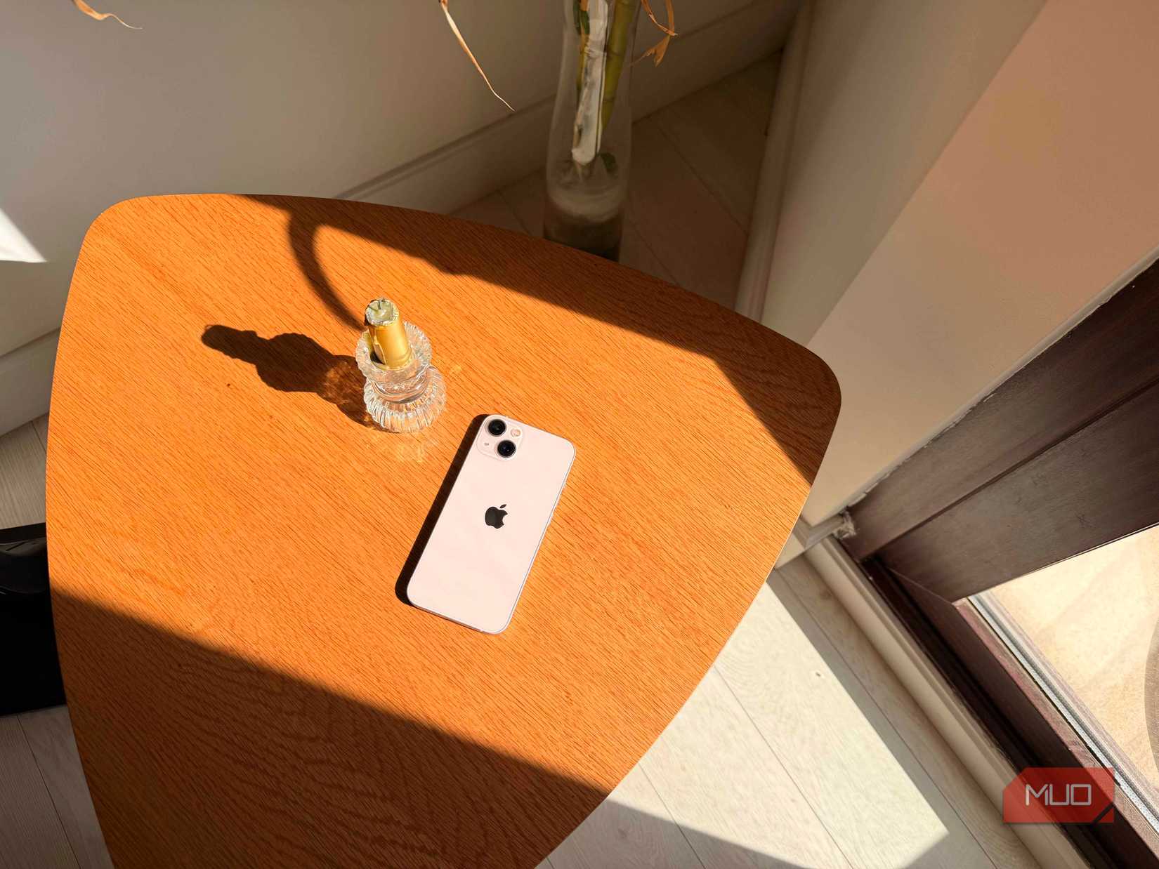 An iPhone next to a candle on a table shot on iPhone 17 Pro