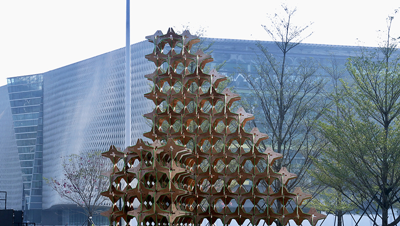 hundreds of interlocking star modules build a porous timber installation - 3