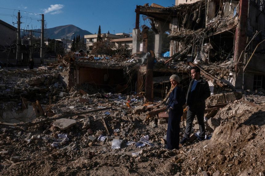 Civilians look upon the remains of a residential and commercial building on Saturday in the Shahrak-e Gharb neighbourhood of Tehran, Iran.
